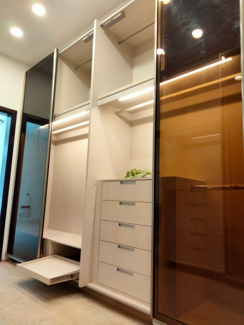 Walk-in wardrobe with tinted glass sliding doors